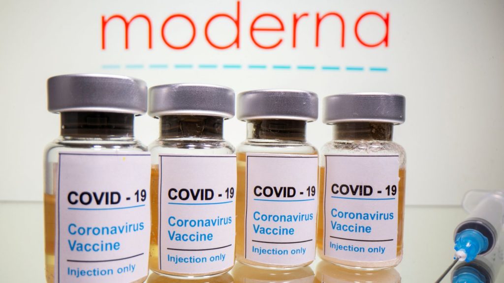 Vials and medical syringe are seen in front of Moderna logo in this illustration. File pic