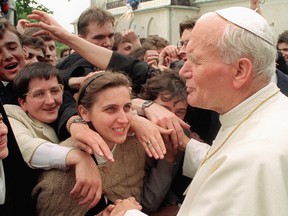 Papież Jan Paweł II, po prawej, komunikuje się z młodymi życzliwymi, przed mszą w Kielce w Polsce w czerwcu 1991 roku.